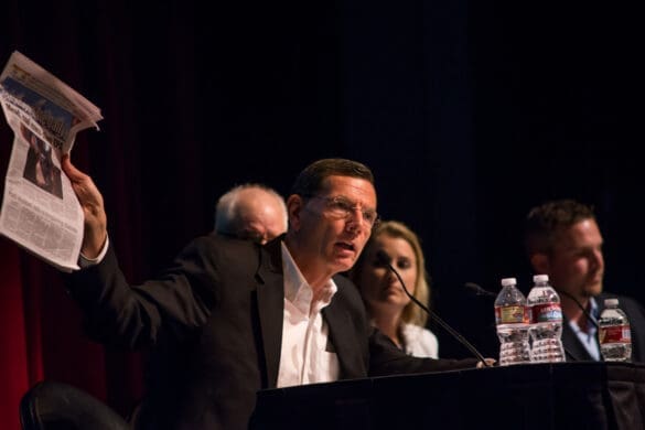 US Senator (R-WY) John Barrasso holds up a copy of the Jackson Hole newspaper featuring the summit