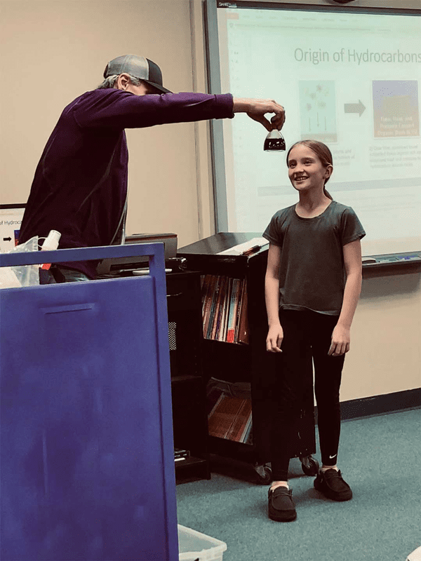 Green shows a Tonkawa Elementary School student what Bakken crude oil looks like when it comes out of the earth.