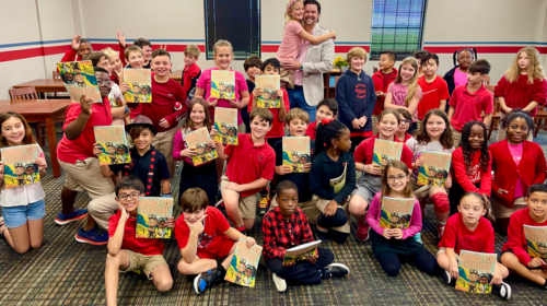 JP Warren reading his book, Energy for Everyone, to elementary school children from kindergarten to sixth grade (shown here with his daughter and her class).