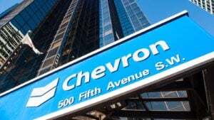 Chevron logo on blue sign in front of skyscraper building