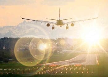 plane in takeoff over glaring solar farm
