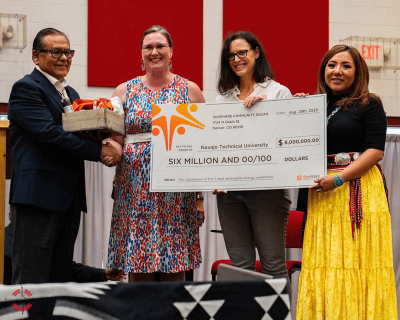 On stage at the Navajo Technical University grant award ceremony in August 2023 with Salina Derichsweiler are Corrina Kumpe COO SunShare, Dr. Buu Nygren President of the Navajo Nation, and Dr. Elmer Guy, President of NTU. Photo courtesy of Salina Derichsweiler.