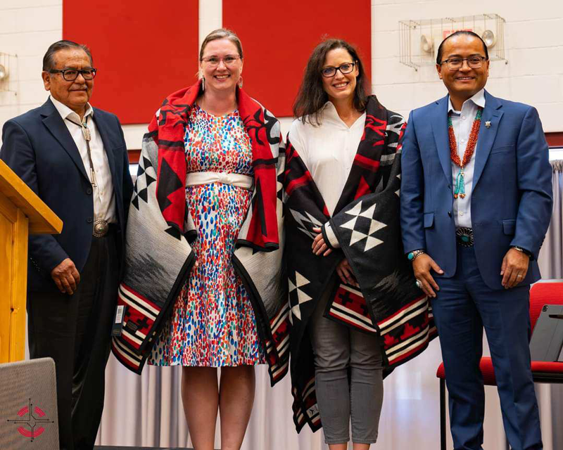 Salina Derichsweiler being draped with a blanket at the grant award ceremony at Navajo Technical University in August 2023 when SunShare delivered the news that $6 million was committed to NTU and $1.2 million was committed to the Coalition to Stop Violence Against Women. Photo courtesy of Salina Derichsweiler.