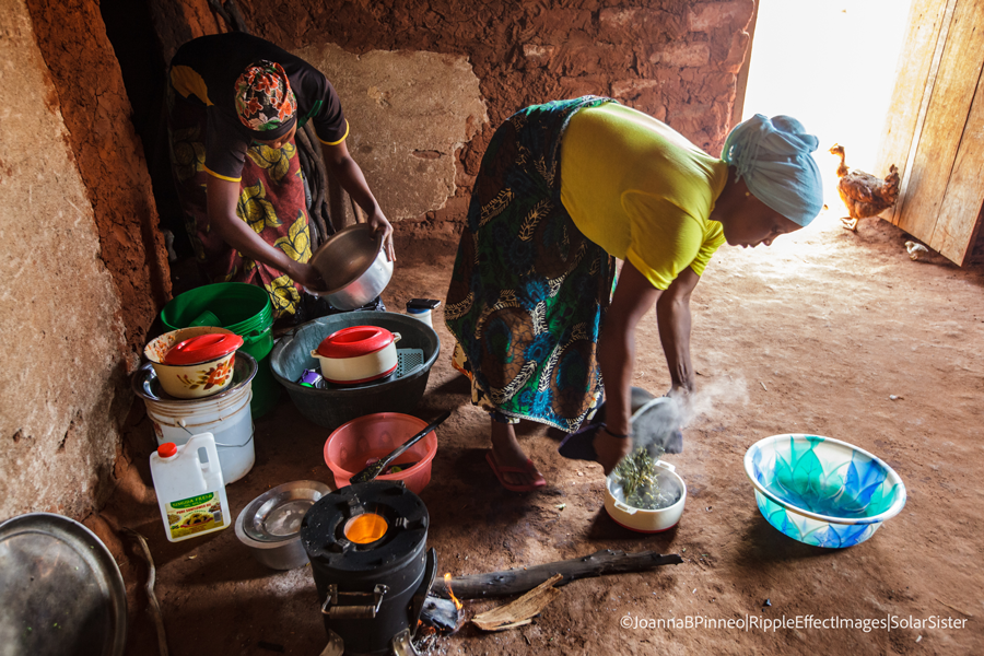 SSE Fatma Mziray (R) and her eldest daughter, Zainabu Ramadhani, 19, cook lunch in her kitchen house using both a clean cookstove using wood and one using coal.