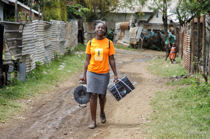 Solar Sister sales agent Mary Anyango, Kisumu, Kenya, taking a clean cookstove to a customer.