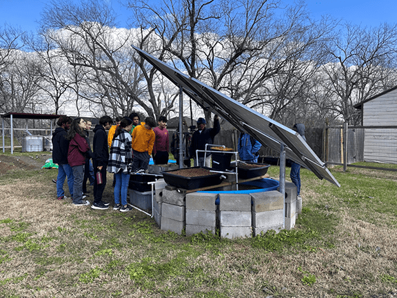 The class toured South Union CDC, an outdoor educational space in Sunnyside, Houston, developed by Efrem Jernigan. Here, students investigated a solar-powered aquaponic system in a community garden.