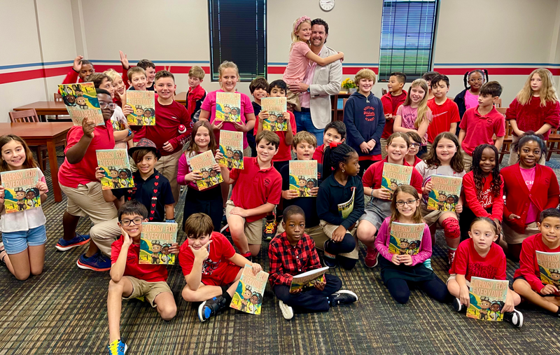 JP Warren reading his book, Energy for Everyone, to elementary school children from kindergarten to sixth grade (shown here with his daughter and her class).